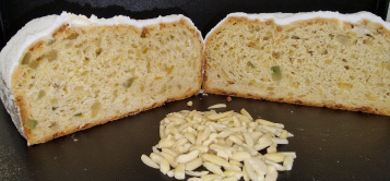 Unser Mandelstollen mit seinen Mandeln im Vordergrund auf einem Häufchen - Der Link auf diesem Bild öffnet das Produkt einzeln.